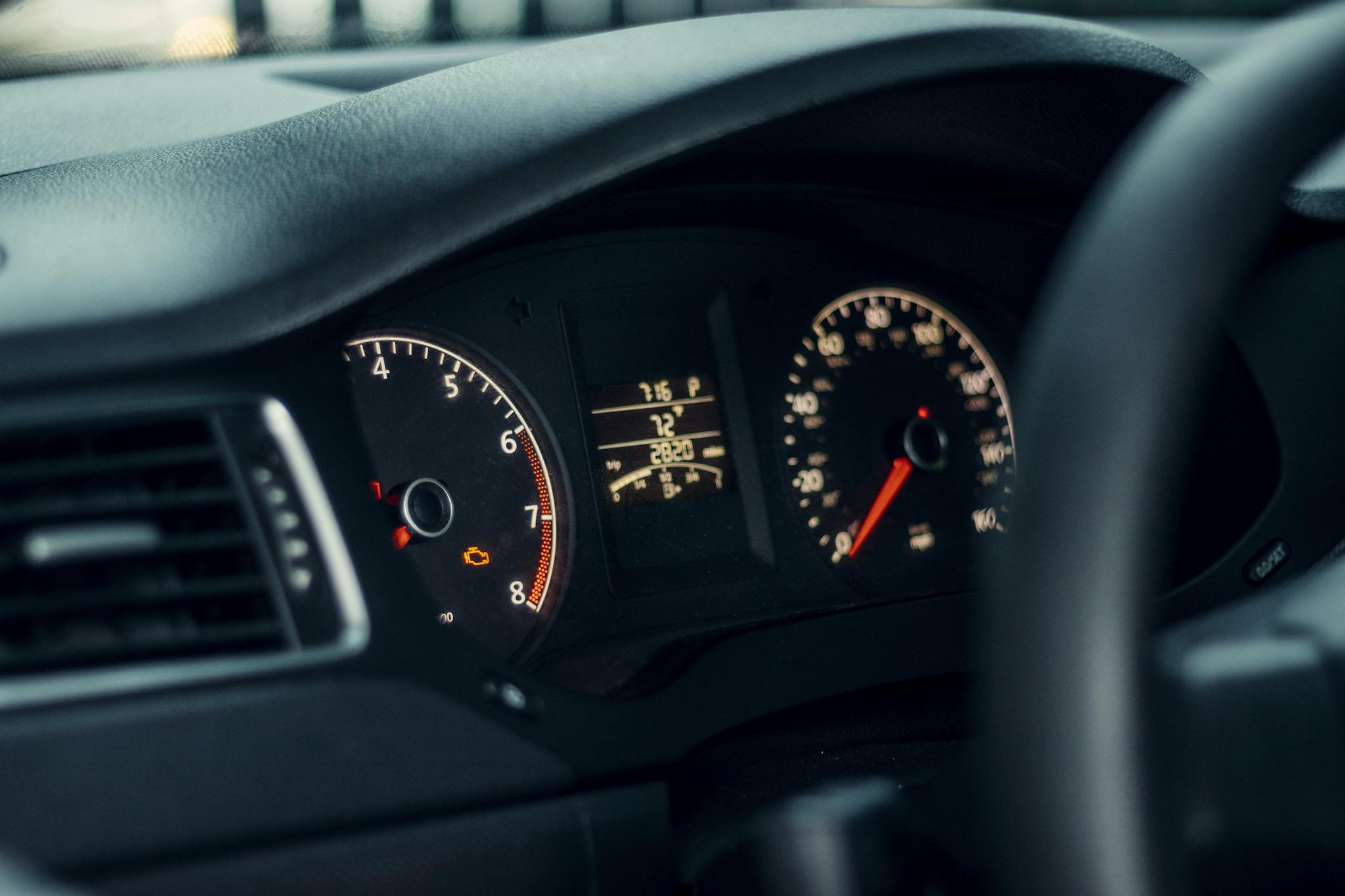 Detailed view of a car's dashboard featuring illuminated gauges and speedometer.