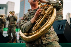 Dynamic military band performance in Seoul featuring brass instruments and urban backdrop.