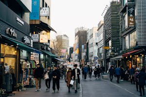 Lively shopping street in Seoul with people walking, shops, and vibrant city life.